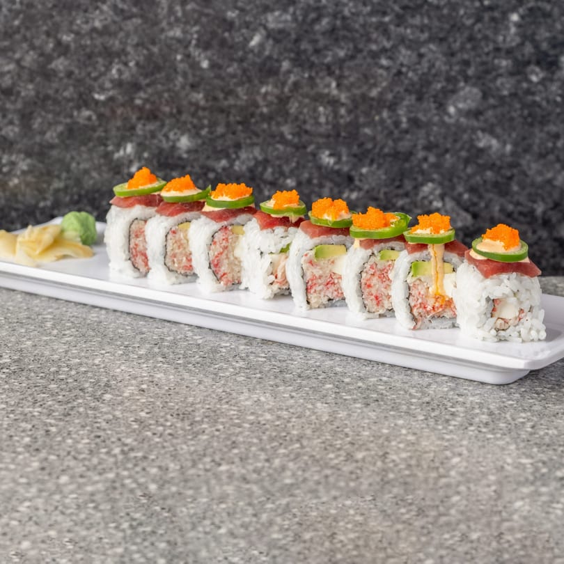 Sushi rolls with tuna, avocado, crab, jalapeño, and roe, served with ginger and wasabi.